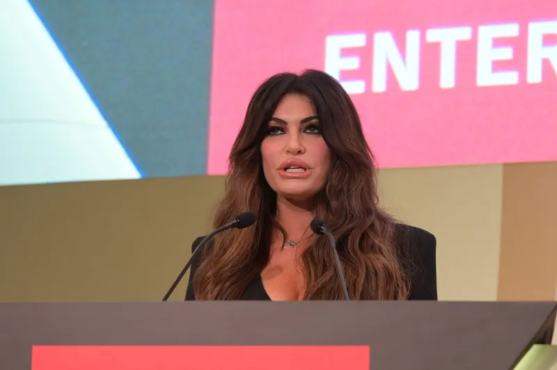 Ambasadoarea SUA în Grecia, Kimberly Guilfoyle, ar fi făcut o declarație care sugerează o posibilă implicare americană în căderea Guvernului Bolojan. Afirmația, relatată de The Wall Street Journal, ar fi fost făcută în martie, la o cină la Atena.

O declarație atribuită ambasadoarei Statelor Unite în Grecia, Kimberly Guilfoyle, ridică semne de întrebare privind circumstanțele politice care au precedat demiterea Guvernului condus de Ilie Bolojan și aruncarea României într-o criză politică fără precedent.

Potrivit publicației The Wall Street Journal, diplomata americană ar fi invocat situația politică din România în timpul unei discuții tensionate purtate în luna martie cu ministrul grec al Energiei, Stavros Papastavrou.

Ambasadoarea SUA în Grecia sugerează implicarea lui Trump în căderea Guvernului Bolojan: „Putem face asta oricărei țări”
În contextul perspectivei căderii Guvernului Bolojan, Guilfoyle ar fi afirmat: „Putem face asta oricărei țări dorim. Putem face asta și aici”.

ADVERTISING

Afirmația este cu atât mai sensibilă cu cât ar fi fost făcută cu aproximativ două luni înainte ca Executivul de la București să fie demis prin moțiune de cenzură de PSD și extremiștii AUR.

Citește și: „Cumetrie”, la Casa Albă. Donald Trump și-a numit nora ambasador al SUA în Grecia

Sorin Grindeanu, la masă cu ambasadoarei Statelor Unite în Grecia
Episodul ar fi avut loc în timpul unei cine organizate în martie la Atena, la care participau oficiali americani și greci. Kimberly Guilfoyle, una dintre susținătoarele americane ale Coridorului Vertical de Gaze, ar fi intrat într-un schimb tensionat de replici cu ministrul grec al Energiei.

Ambasadoarea SUA în Grecia, Kimberly Guilfoyle - Foto: Profimedia images
Kimberly Guilfoyle - Foto: Profimedia images
După afirmația referitoare la România, Papastavrou i-ar fi răspuns că Statele Unite nu pot schimba Guvernul Greciei, deoarece acesta a fost ales de cetățeni.

În România, luna martie coincidea cu o perioadă de tensiuni tot mai mari în interiorul coaliției. PSD se pregătea pentru o consultare internă privind continuarea participării la guvernarea alături de PNL.

Citește și: SUA va avea o nouă ambasadaroare în Grecia. Este logodnica lui Trump Junior

Ad 
Sorin Grindeanu anunțase încă din februarie intenția de a supune la vot în partid două variante: continuarea guvernării cu Ilie Bolojan premier sau solicitarea unui alt prim-ministru din partea PNL.

Consultarea organizată în aprilie s-a încheiat cu o majoritate categorică în favoarea ieșirii PSD de la guvernare. În luna următoare, PSD și AUR au depus și votat moțiunea de cenzură care a dus, pe 5 mai, la demiterea Cabinetului Bolojan.

În acest context apare și un alt episod. La 31 martie, Kimberly Guilfoyle a participat la o întâlnire la restaurantul Isoletta din București, unde s-ar fi aflat și Sorin Grindeanu, consilierul prezidențial Florin Vlădică și ministrul Energiei de la acel moment, Bogdan Ivan.

Miza gazelor americane și refuzul Guvernului Bolojan
În spatele disputei se află și o miză economică importantă: Coridorul Vertical de Gaze, infrastructură destinată transportului gazelor din Grecia către Bulgaria, România, Ungaria, Slovacia, Republica Moldova și Ucraina.

Statele Unite susțin dezvoltarea infrastructurii care permite gazului natural lichefiat american să ajungă în regiune. GNL-ul este transportat pe mare, regazeificat în terminale și introdus ulterior în rețeaua de conducte.

Proiectul s-a confruntat însă cu o problemă comercială: costurile generate de lichefiere, transport, regazeificare și intermediari au făcut ca oferta să fie mai puțin atractivă pentru cumpărătorii privați.

În ianuarie, Bogdan Ivan, pe atunci ministru al Energiei, le-ar fi trimis președintelui Nicușor Dan și premierului Ilie Bolojan scrisori prin care solicita încheierea unui acord guvernamental cu Statele Unite pentru achiziționarea de GNL american prin intermediul Nova Gas&Trade.

Ivan ar fi solicitat inclusiv un „mandat explicit” pentru negocieri „cu sprijinul” SRI, argumentând necesitatea evitării „riscului unui blocaj diplomatic cu partenerul strategic SUA”.

Administrația Prezidențială și Guvernul Bolojan nu au dat însă curs propunerii în forma solicitată, pe fondul întrebărilor privind costurile și oportunitatea economică a achizițiilor.

Interesul Washingtonului pentru piața energetică regională fusese confirmat public și de președintele Nicușor Dan.

„Este interesul american de a intra cu LNG pe piața europeană. Noi vrem să avem o prezență americană în România și vrem ca această configurație economică să fie favorabilă României”, declara Nicușor Dan, președintele României, în aprilie.

Discuția este complicată și de apropierea începerii producției de gaze din Marea Neagră. Romgaz, companie controlată majoritar de stat, deține 50% din proiect, alături de OMV Petrom, iar volumele estimate ar putea acoperi necesarul intern al României.

Partenerul român al consorțiului americano-grec implicat în Coridorul Vertical este Nova Power & Gas, companie controlată de frații Teofil și Simion Mureșan. Firma este implicată, alături de compania americană NuScale și Nuclearelectrica, și în proiectul reactoarelor modulare de la Doicești.

Guvernul Bolojan a ridicat semne de întrebare și asupra acestui proiect. Fostul premier a reclamat cheltuieli de aproape un miliard de lei fără rezultate concrete și a trimis Corpul de Control la Nuclearelectrica. Ulterior, directorul general al companiei, Cosmin Ghiță, a demisionat.